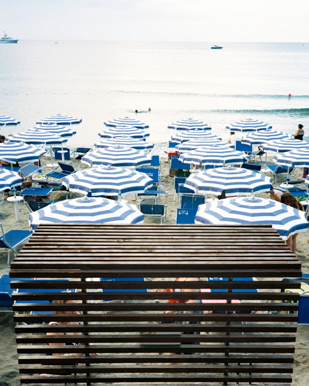 a beach filled with lots of blue and white umbrellas