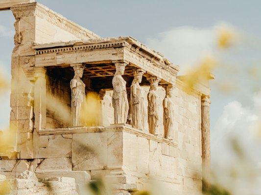 A group of statues on the side of a building — Athens, Greece