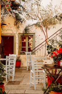 a patio with tables and chairs and potted plants