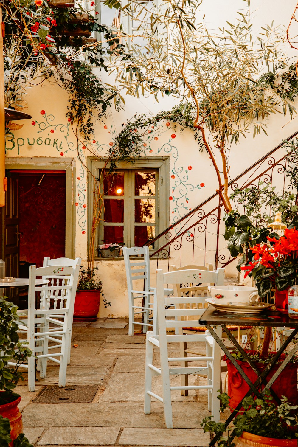 eine Terrasse mit Tischen und Stühlen und Topfpflanzen