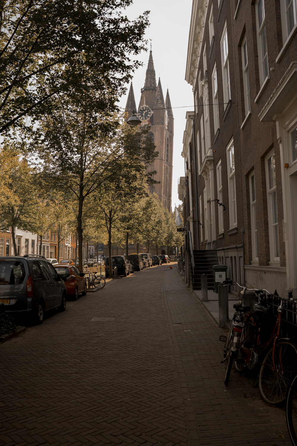 a city street lined with parked cars and tall buildings