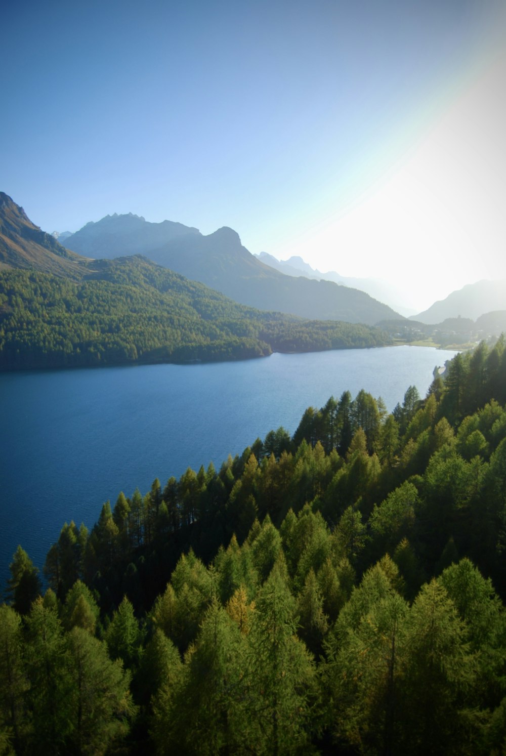 Um lago cercado por árvores verdes e montanhas