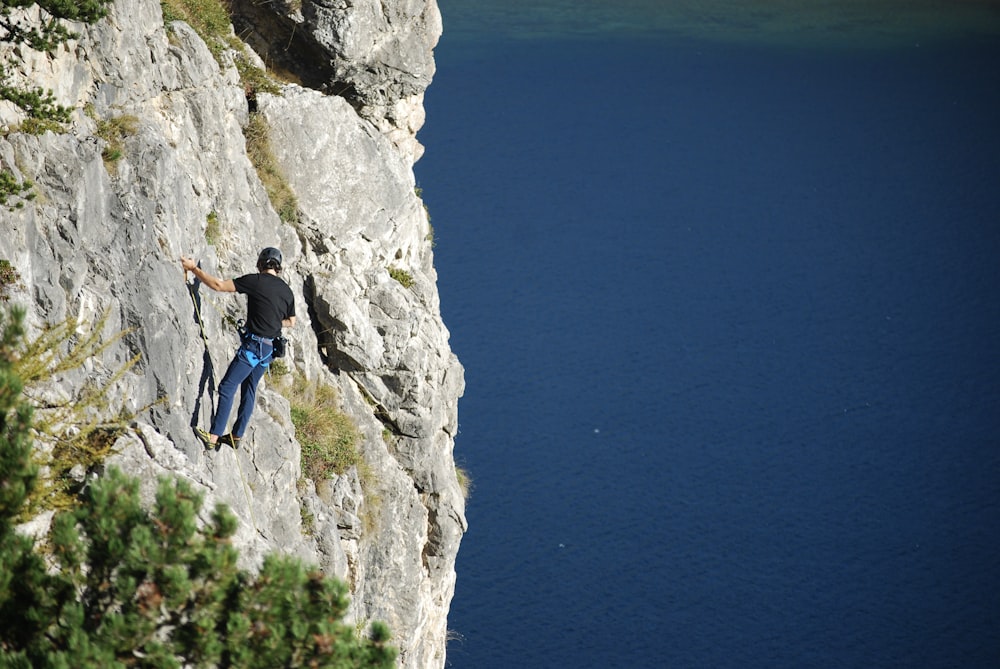 Un hombre trepando por la ladera de una montaña