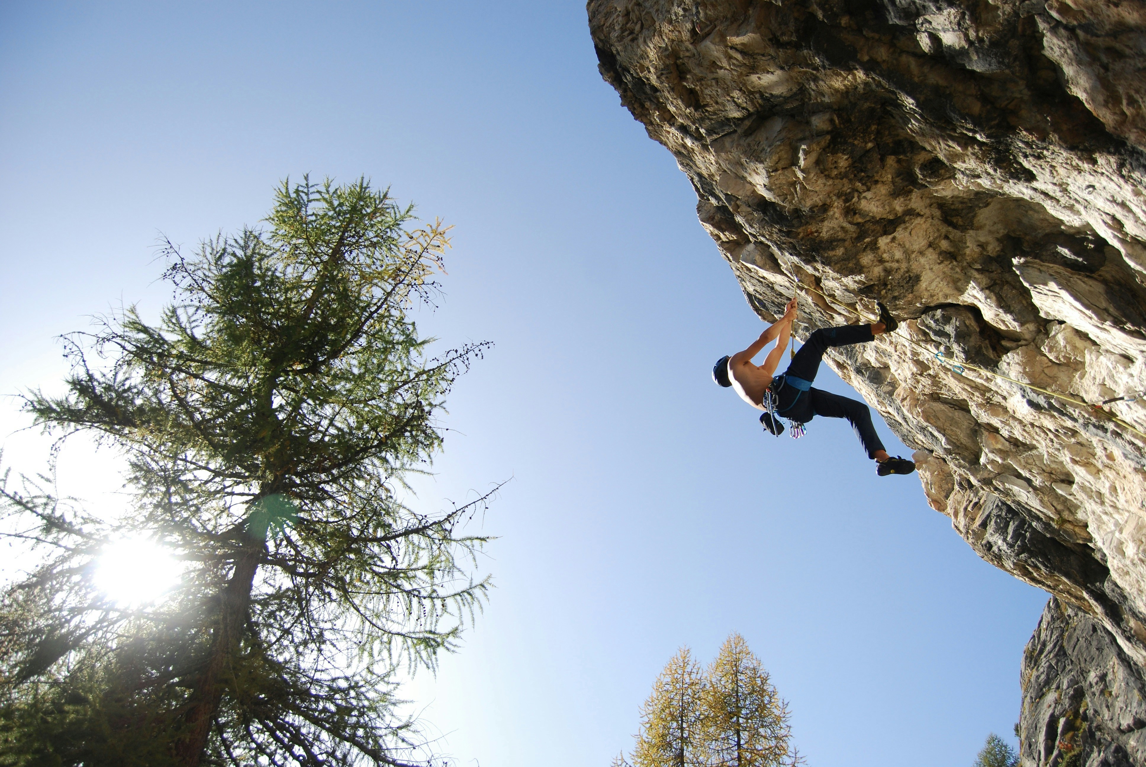 a man climbing up the side of a cliff, 