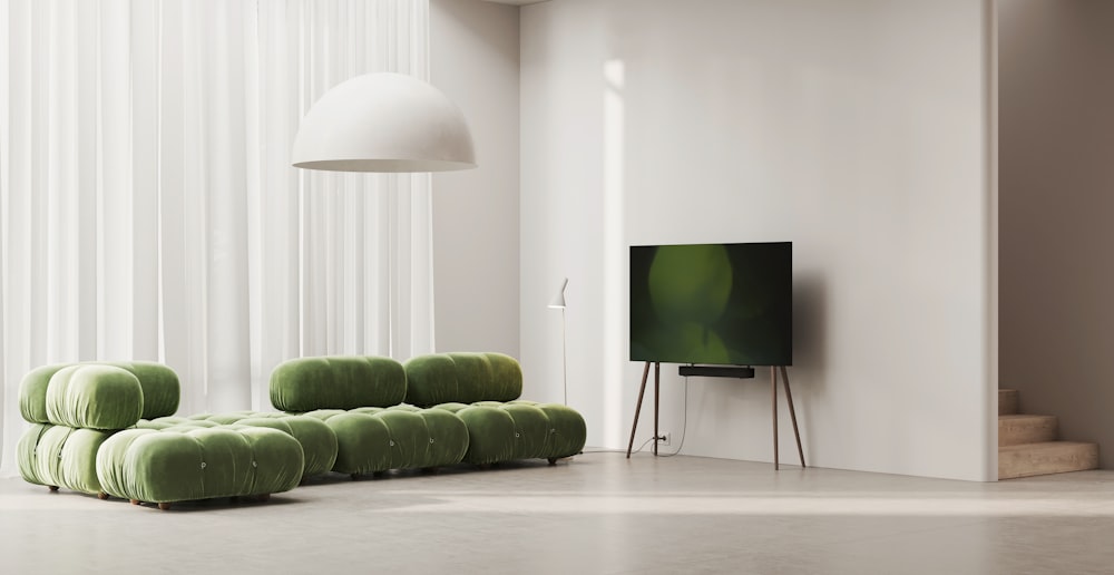 a living room with a television and green couches