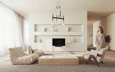 a woman standing in a living room next to a fireplace