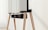 A modern television set up on sleek, angled wooden legs with a soundbar positioned directly beneath it. The design is minimalist and stylish, integrating functionality with aesthetics in a clean, contemporary space.