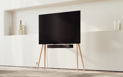 A classic Sanyo TV set on a wooden stand in a bright, minimalist room.