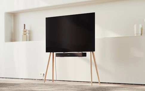 A sleek modern TV setup with a Nextstar Midyat box on a wooden stand