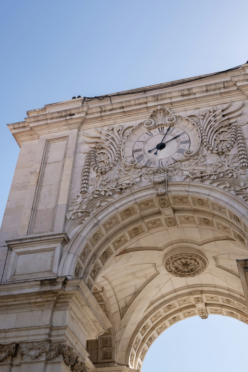 a clock mounted to the side of a stone arch