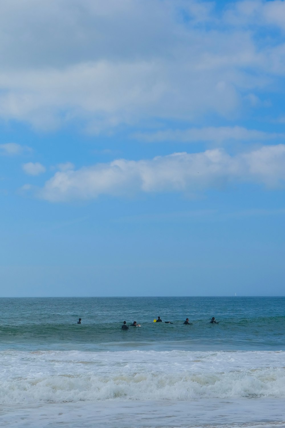 a group of people riding surfboards on top of a wave