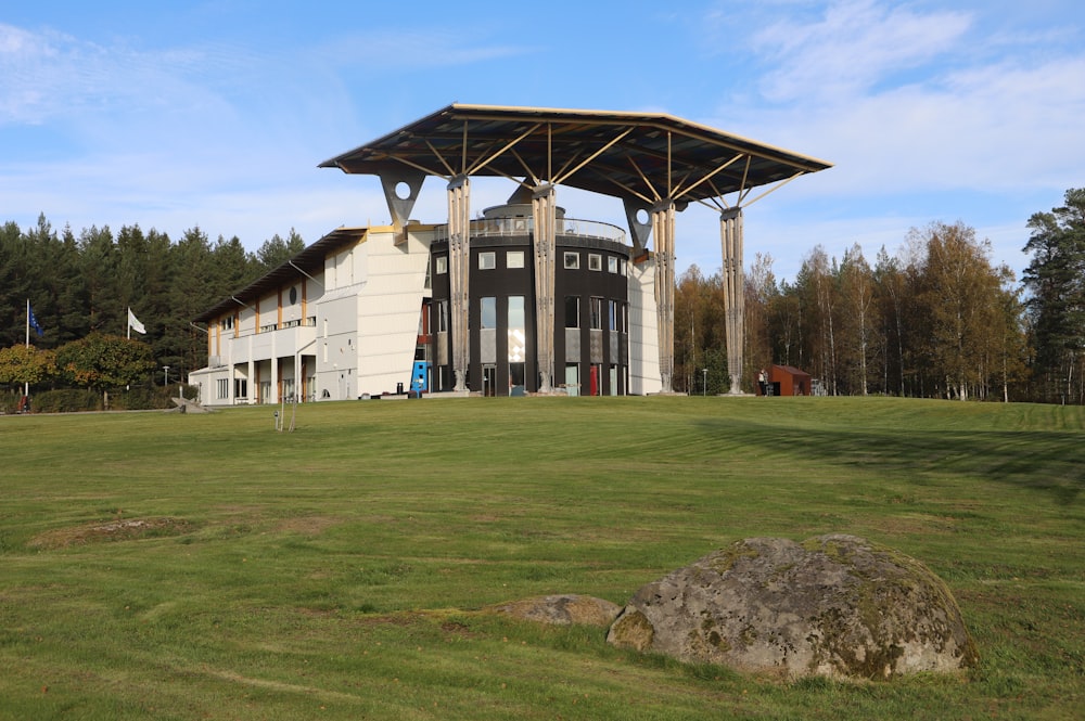 a large white building sitting on top of a lush green field