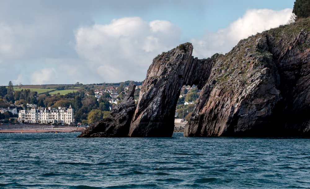 a large rock formation in the middle of a body of water