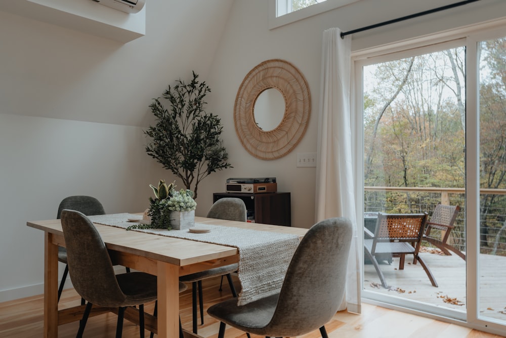 a dining room table with chairs and a potted plant