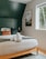 a bed with a white blanket and two folded towels on top of it