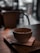 A steaming cup of coffee on a rustic wooden table surrounded by cozy seating and warm lighting.