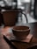 A warm coffee cup placed on a wooden table with pleasing light ambiance.