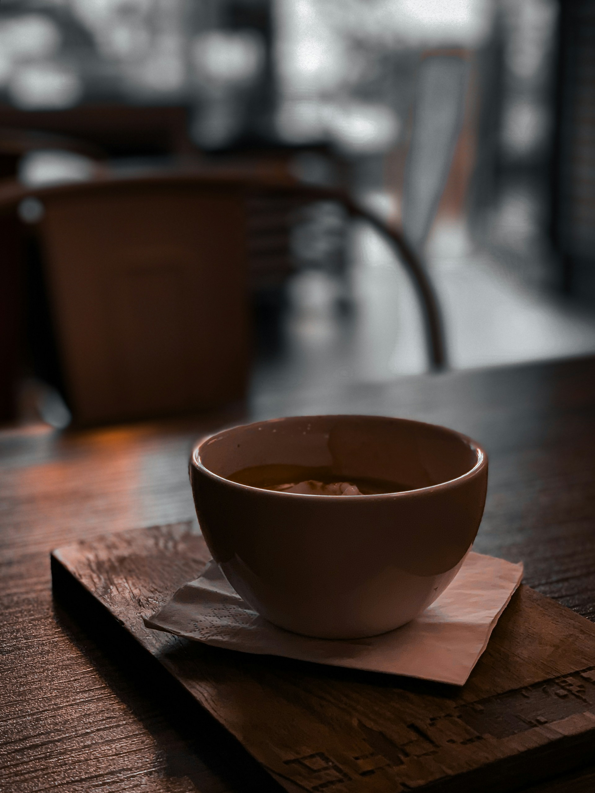 A close-up of a steaming coffee cup on a sleek table, with soft ambient lighting enhancing the mood.