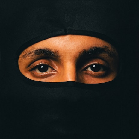 A close-up of a masked hero’s intense gaze, with subtle hints of vulnerability beneath the tough exterior.