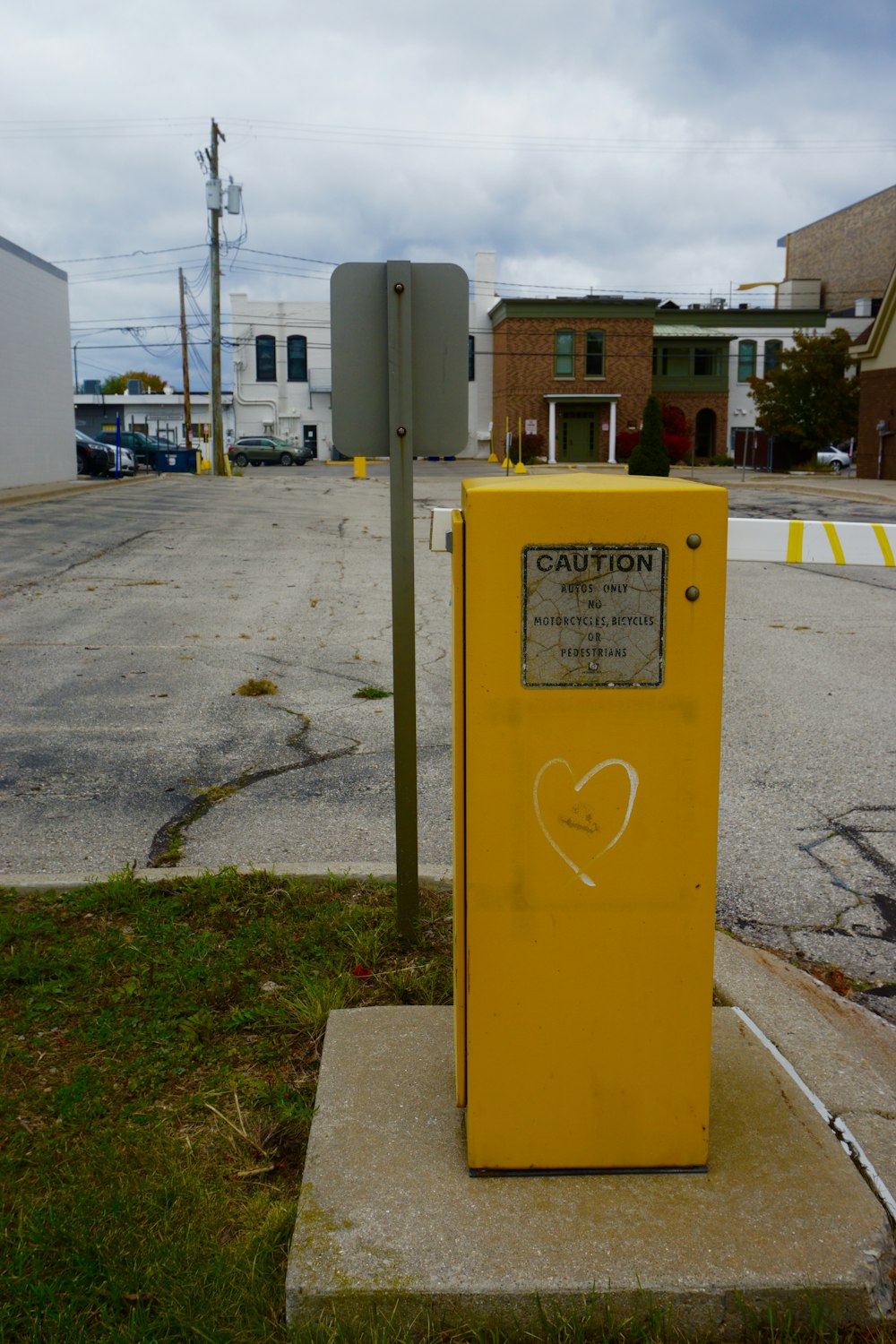 a yellow box sitting on the side of a road