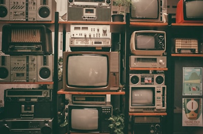 a wall of old televisions and old radio sets