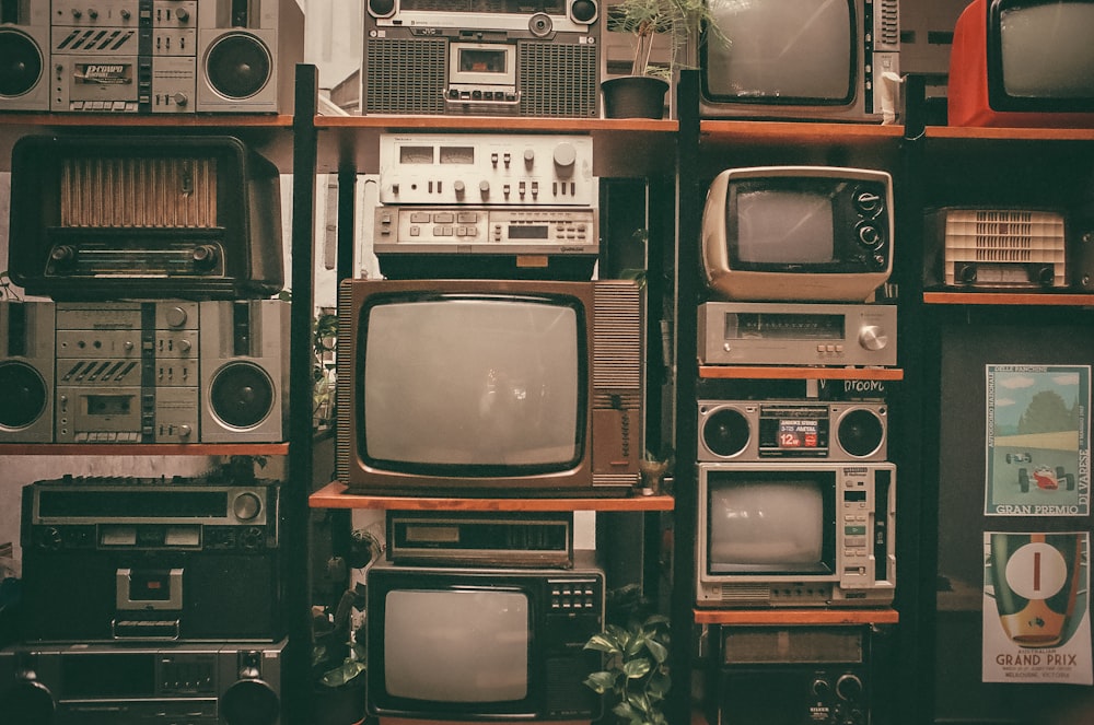 a wall of old televisions and old radio sets
