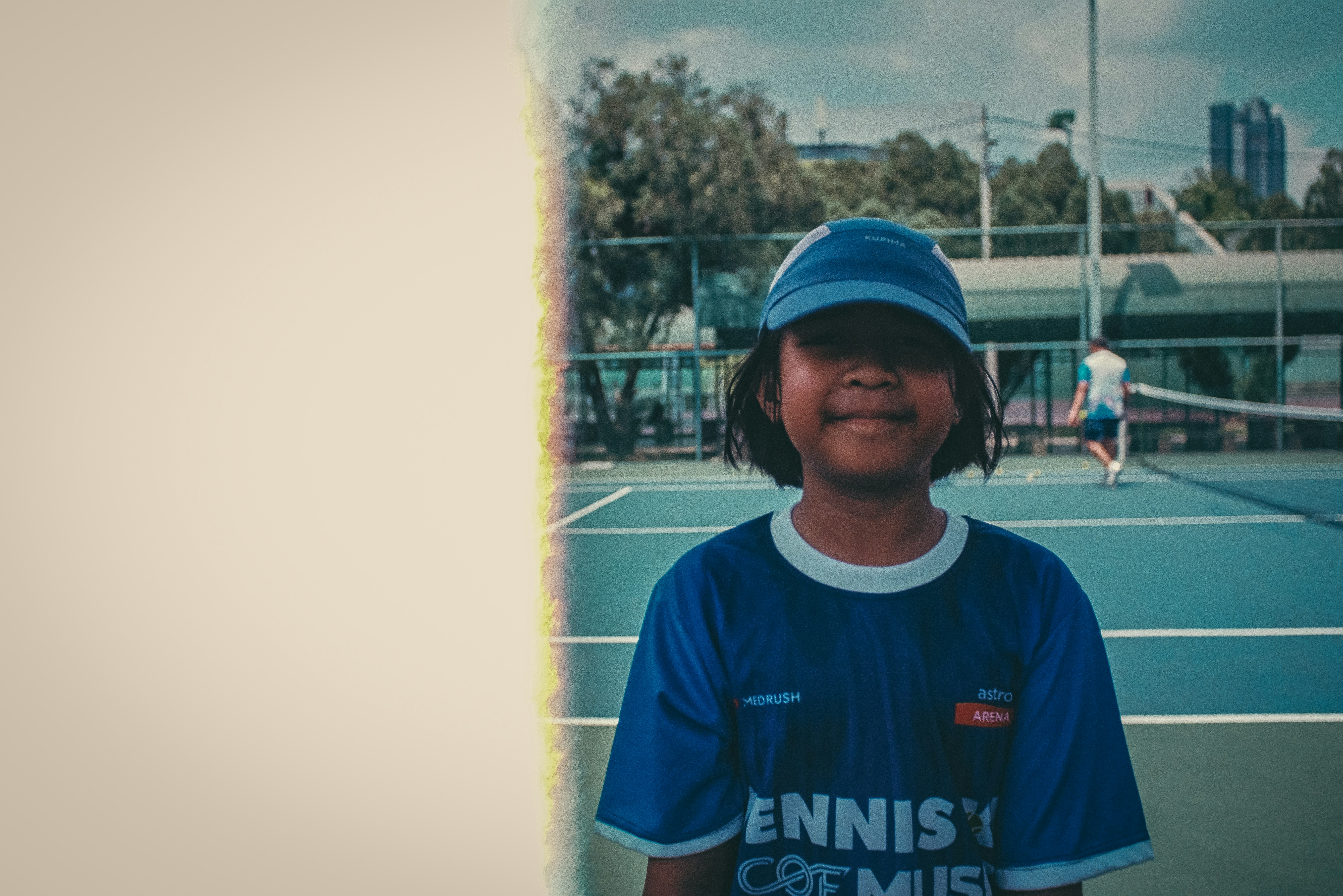 un giovane ragazzo in piedi su un campo da tennis che tiene una racchetta