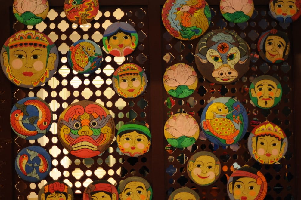 a group of colorful masks hanging on a wall
