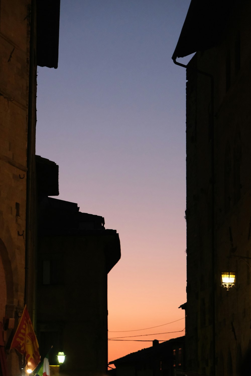 a city street at night with a street light in the distance