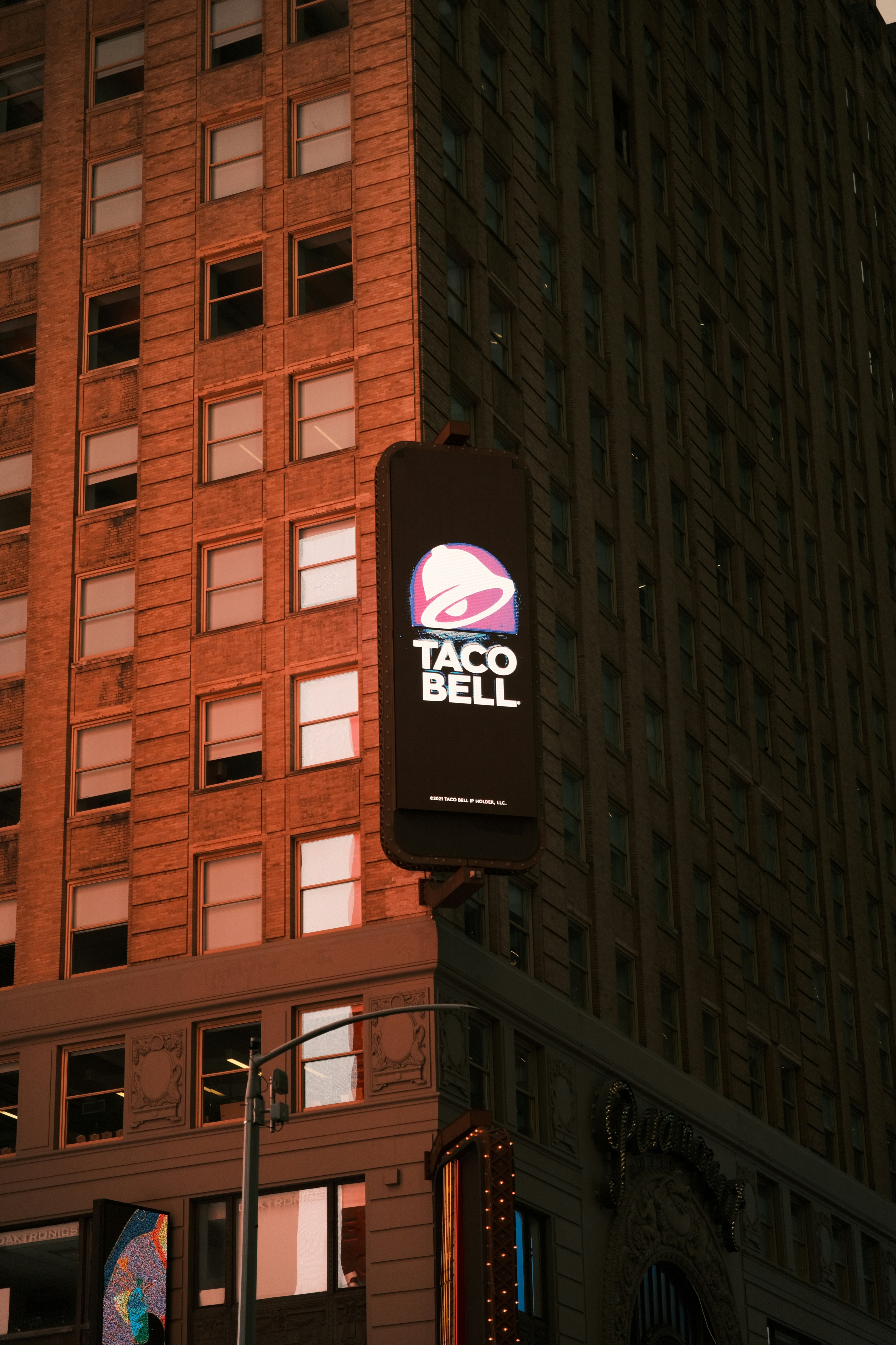 A taco bell sign hanging off the side of a building photo – Free City ...