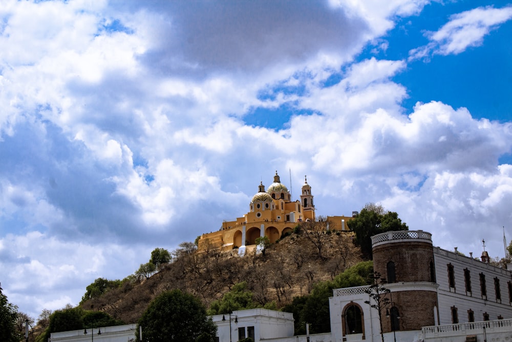 a castle on top of a hill under a cloudy sky