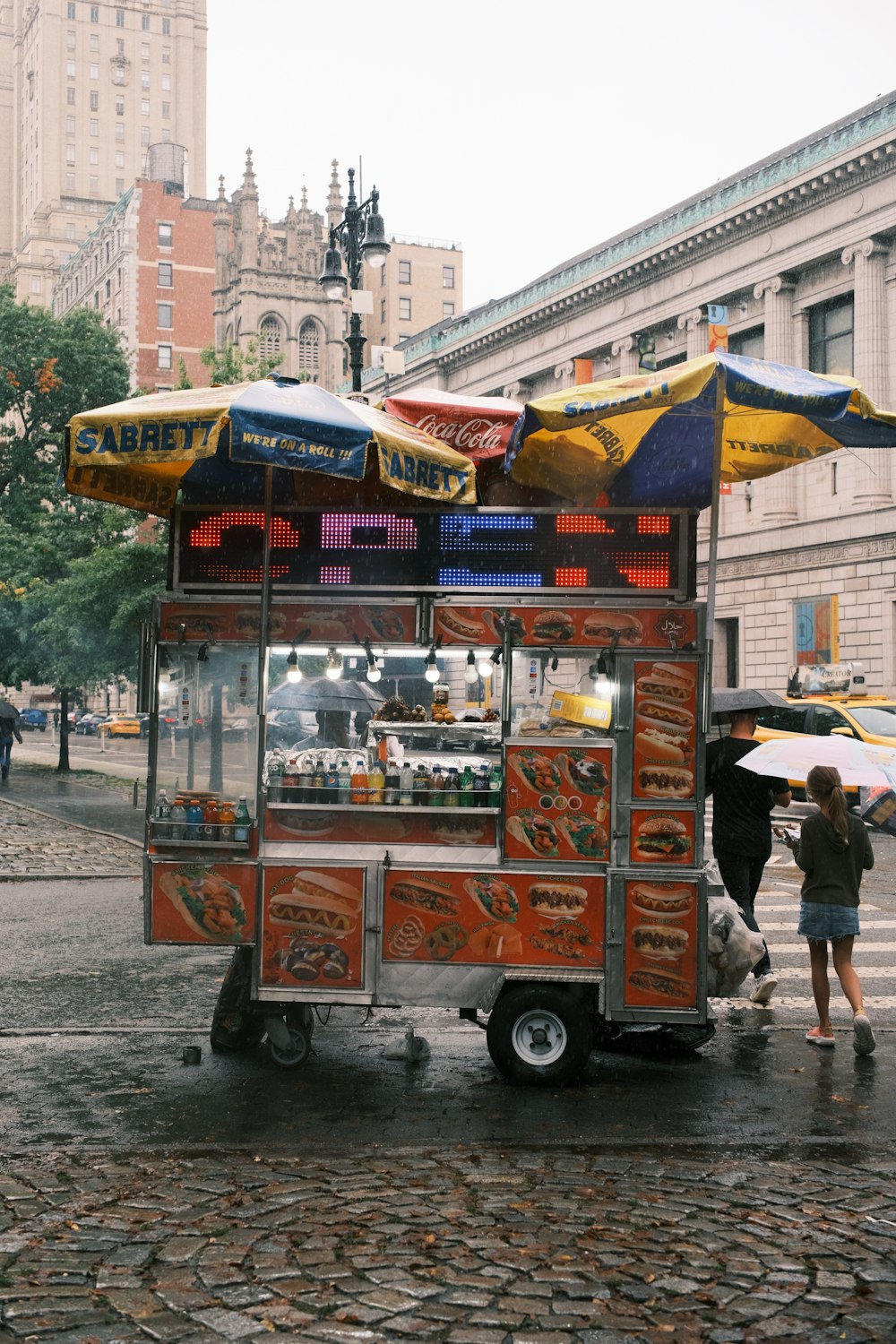 a food cart with umbrellas on a city street