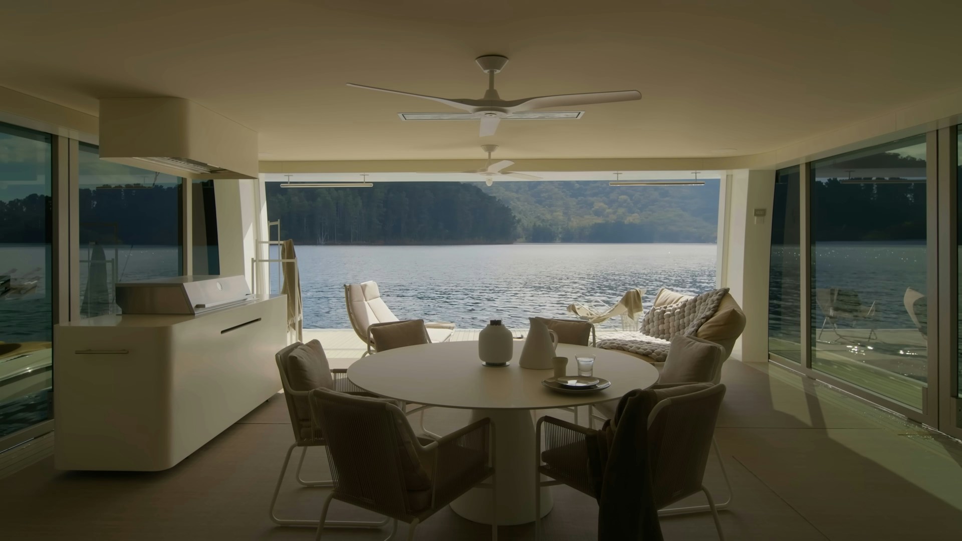 Inside the rental, a stylish living room featuring iconic mid-century modern furniture and large glass doors opening to the lake view.