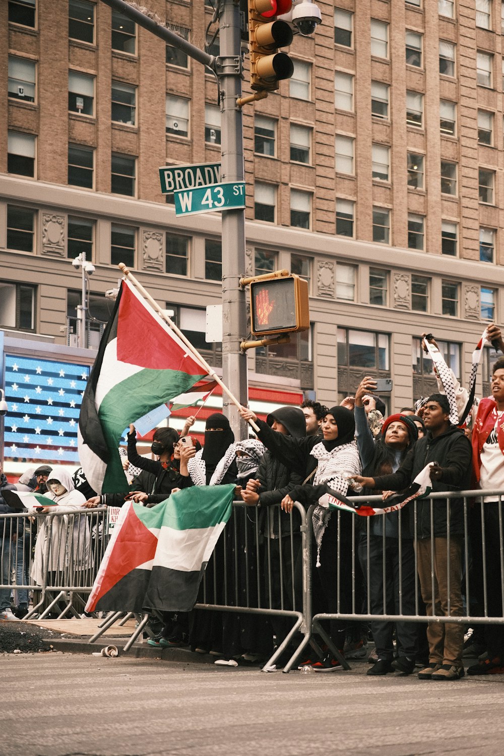 a crowd of people standing next to a metal barricade