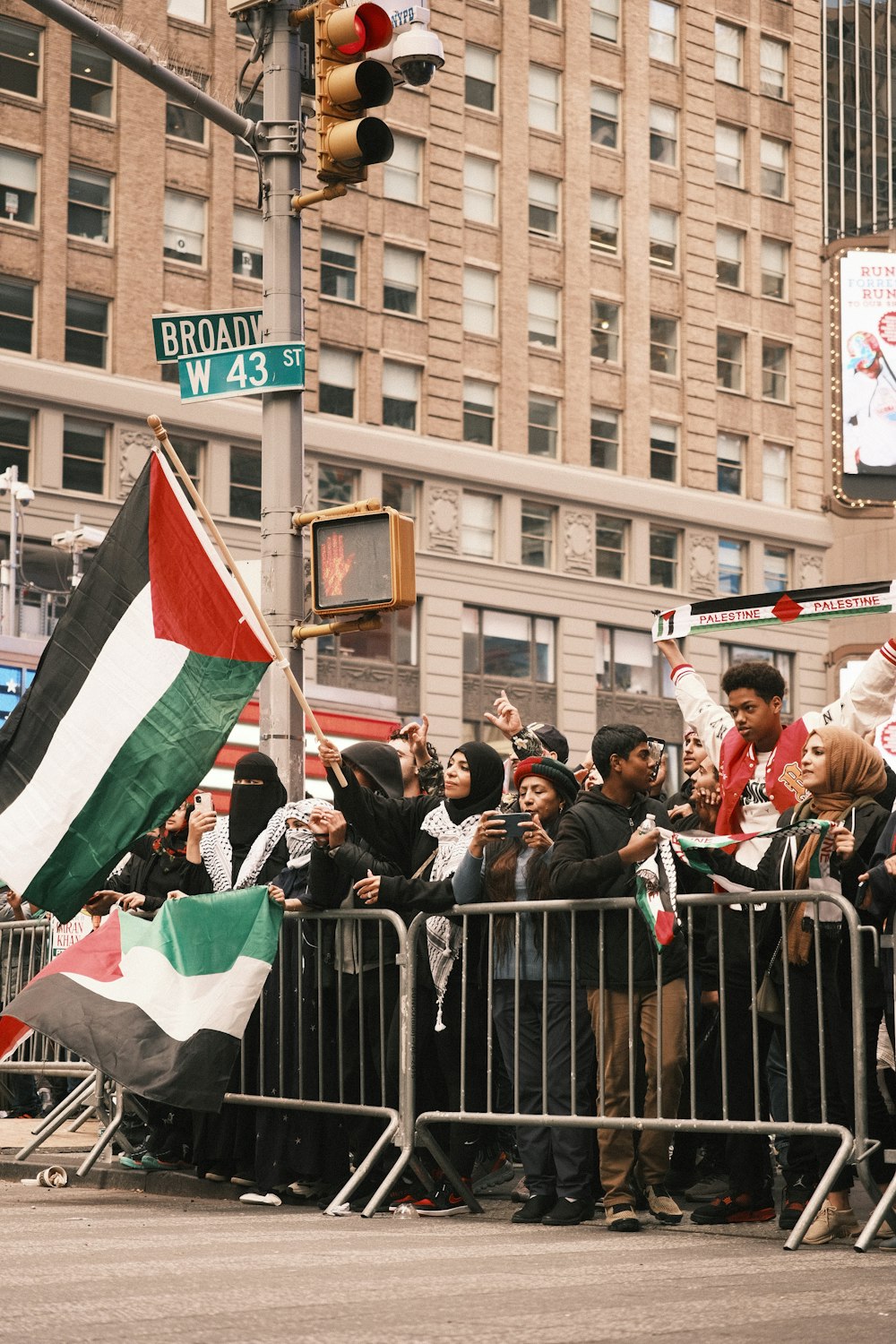 a crowd of people standing next to a metal barricade