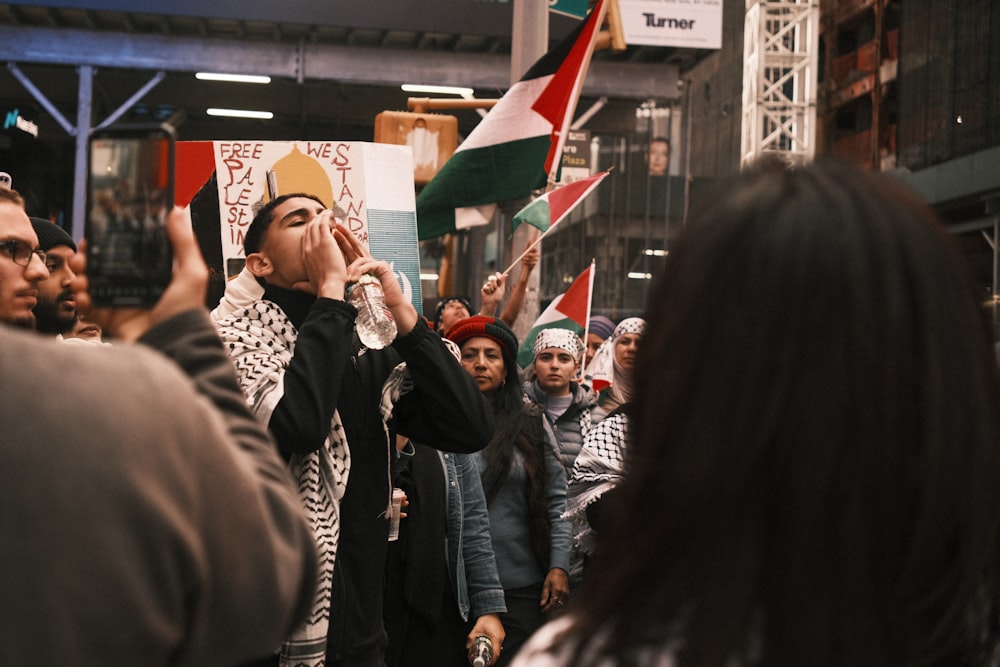 a group of people standing around each other holding flags