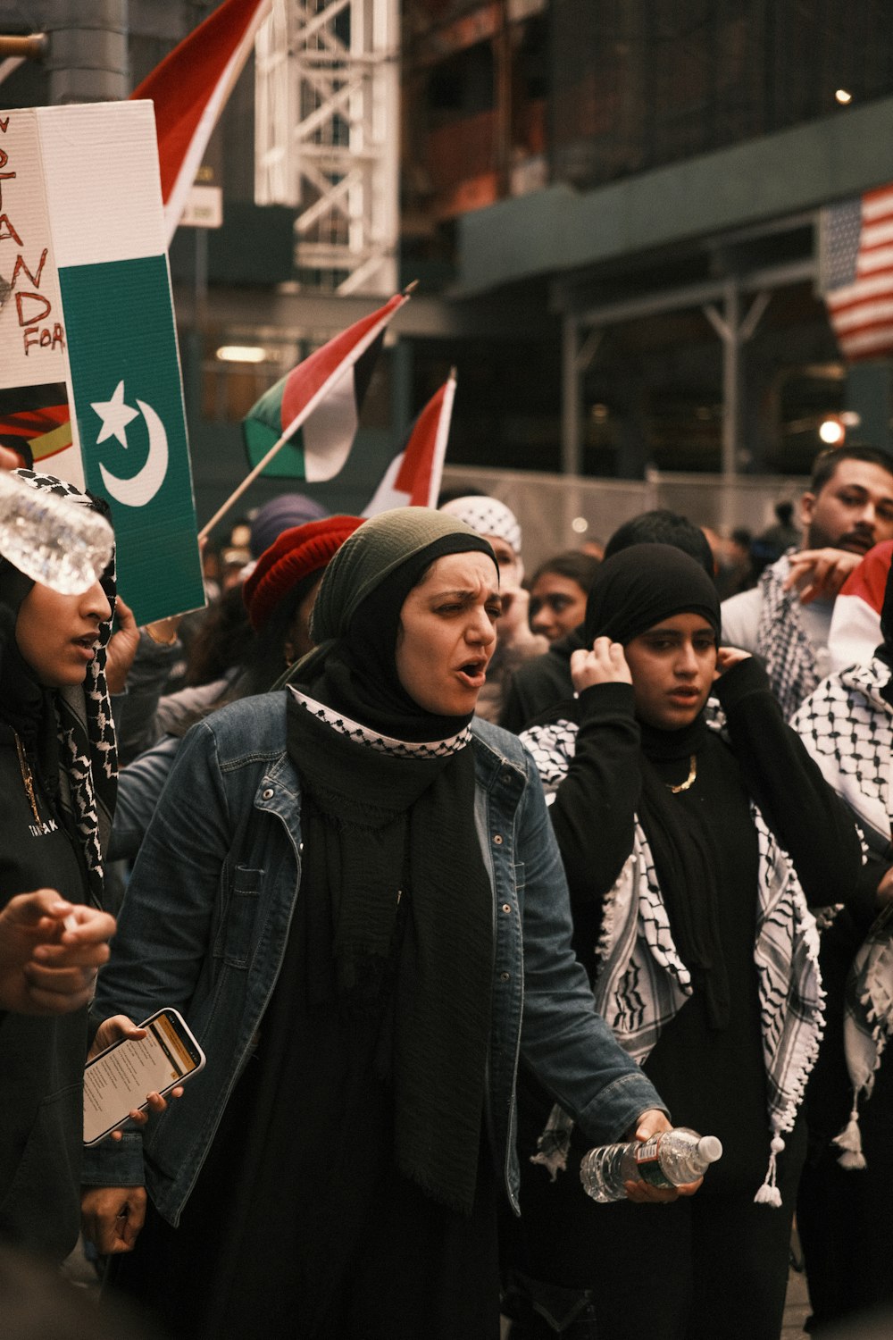 a group of people walking down a street holding flags