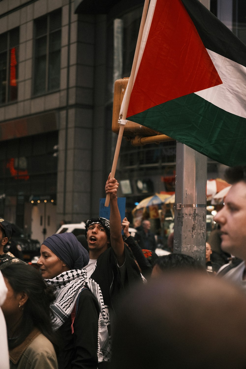 a man holding a flag in a crowd of people