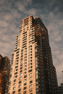 A modern high-rise residential building glowing warmly at sunset in a prime UAE location.