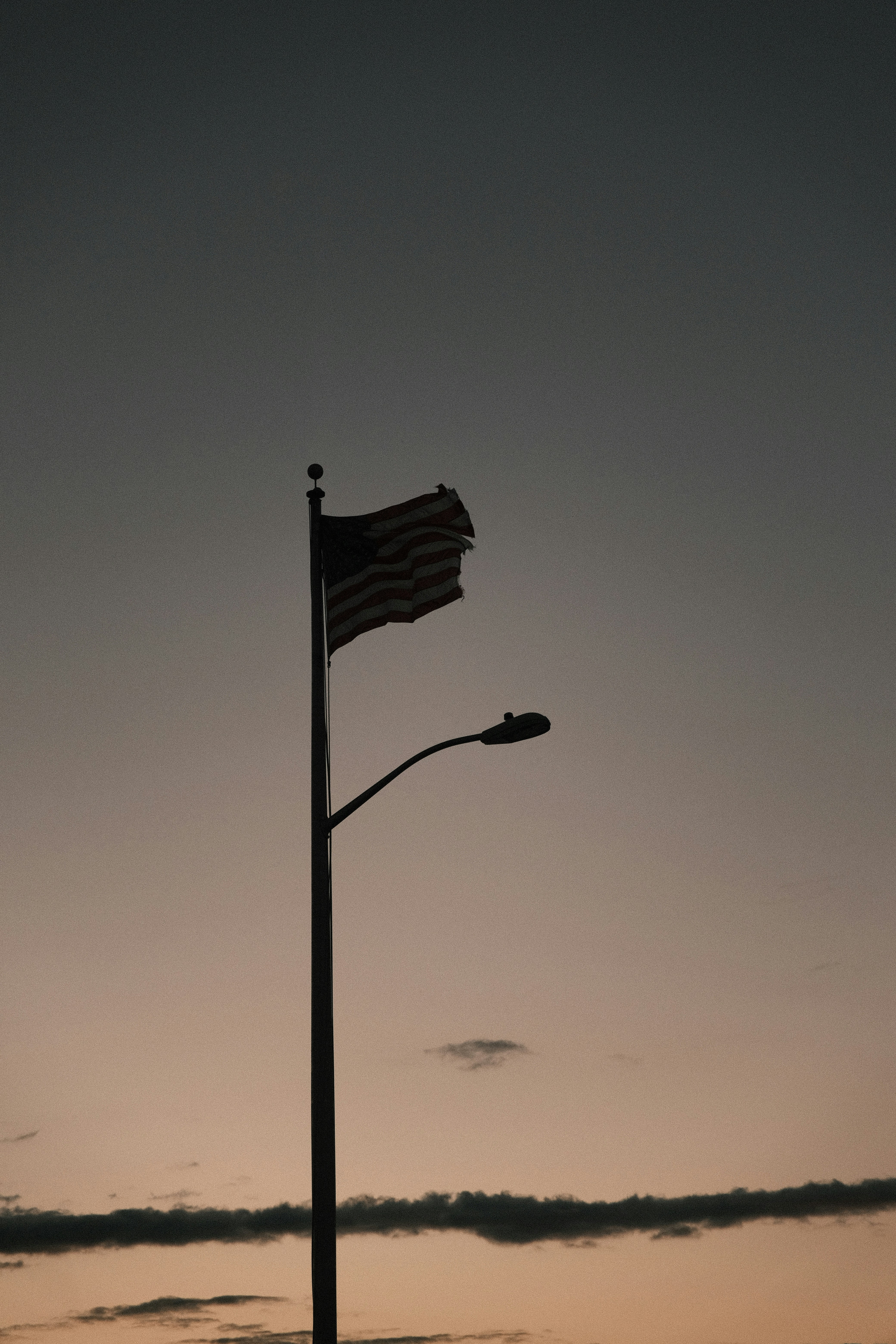 a street light with a flag on top of it