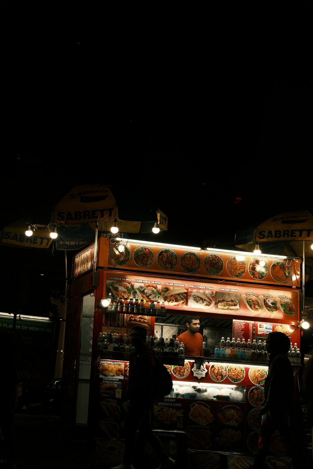 a food stand lit up at night in the dark