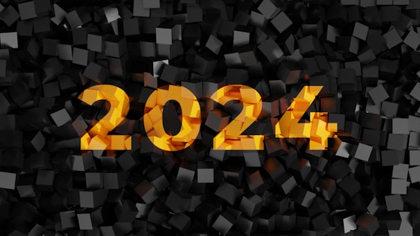 The image features bold yellow numbers '2024' prominently displayed against a textured background of dark, three-dimensional cubes.