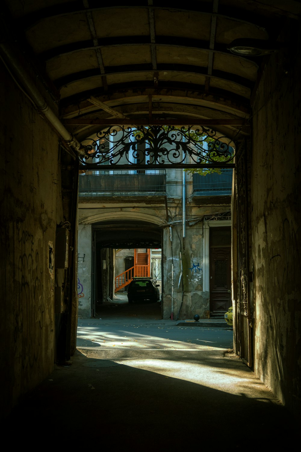 a car is parked in a tunnel between two buildings