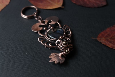 Various custom metal pieces including a keychain, a badge, and a metal tag with detailed engravings.