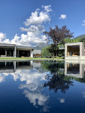 Exterior shot of a house featuring large panoramic windows under blue skies.