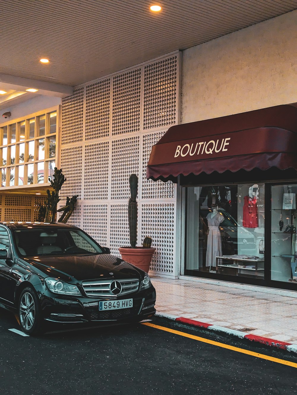 a black car parked in front of a boutique