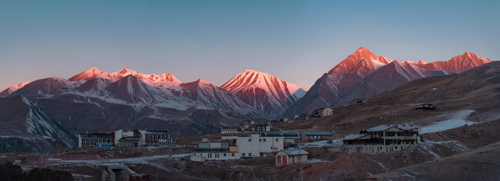 the mountains are covered in snow as the sun sets