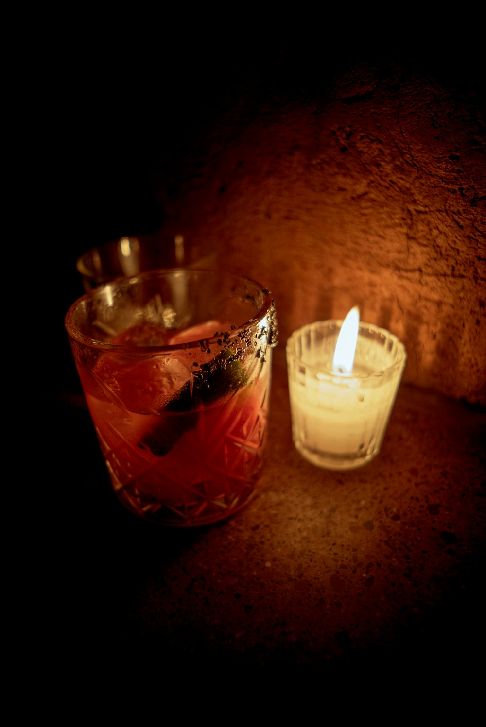 a candle and a glass of wine on a table