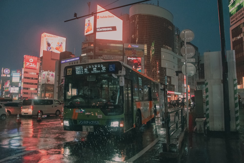 a city bus driving down a rain soaked street