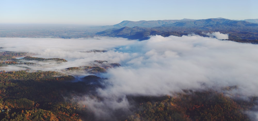 an aerial view of a mountain range covered in clouds